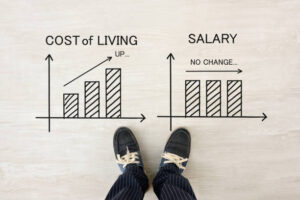 Man' feet with shoes and cost of living and salary transition graphs