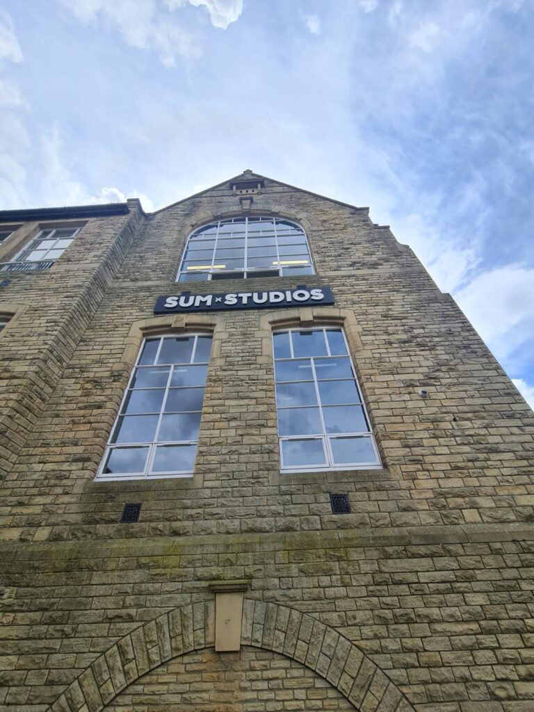 Grade II listed Victorian school building, with Sum Studios sign on the front.