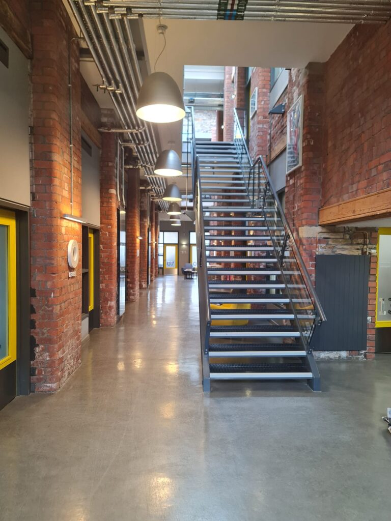Industrial open metal staircase, exposed brick walls